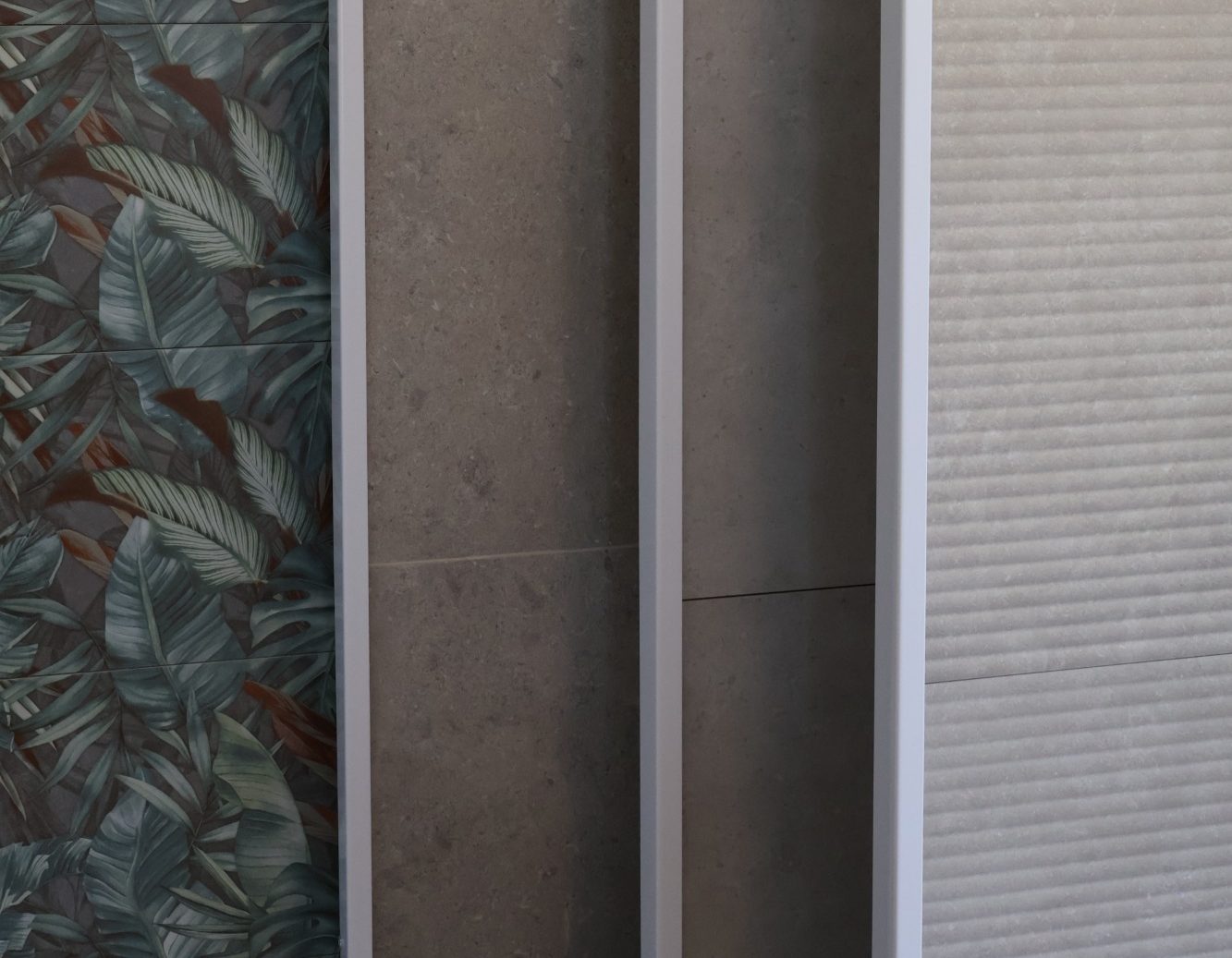 Fliesen im Showroom Fliesenstudio Hesselbach - moderne Paneele mit floralem Design und Natursteinoptik 